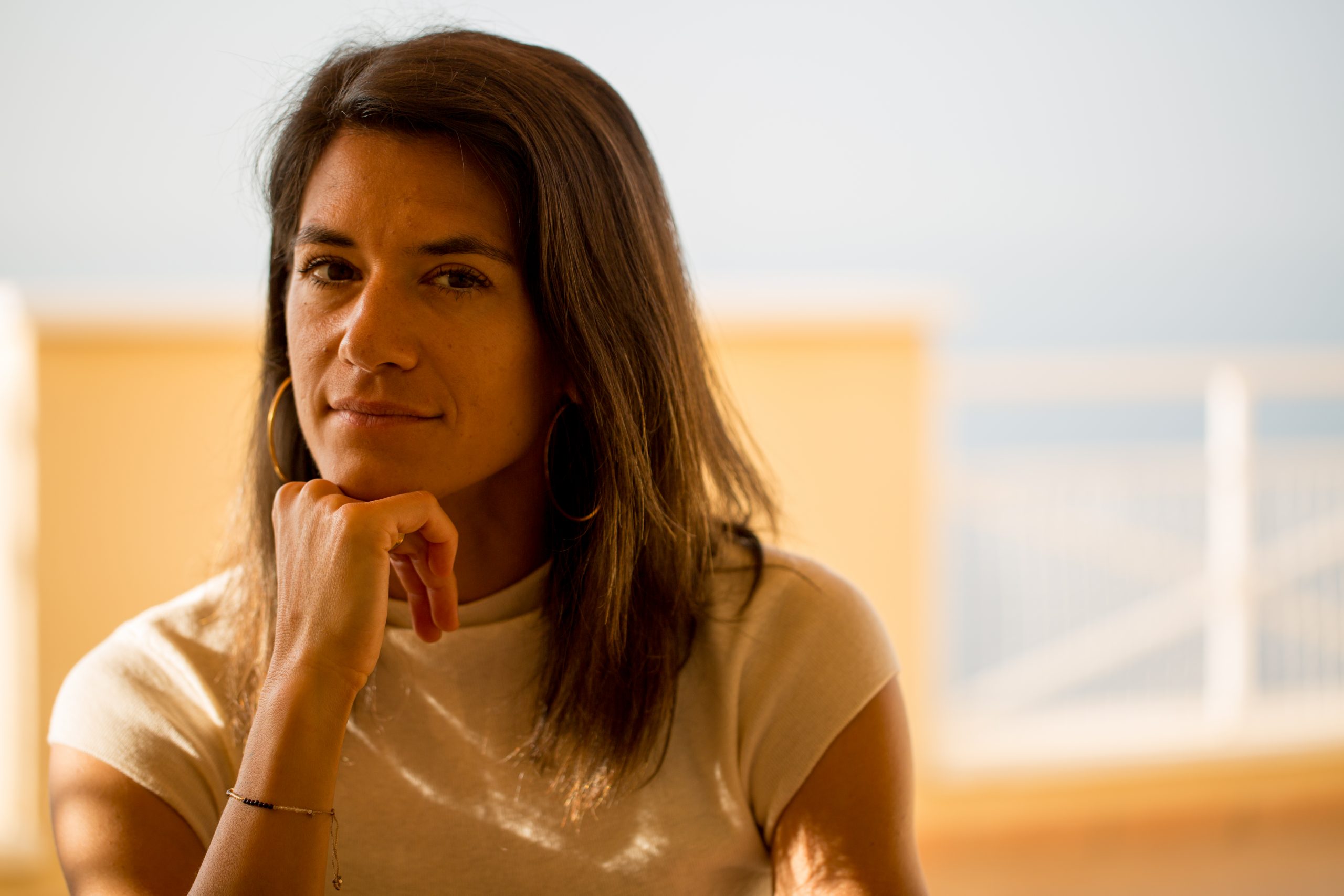 Nathalie Groth st&uuml;tzt nachdenklich l&auml;chelnd das Kinn auf die Hand